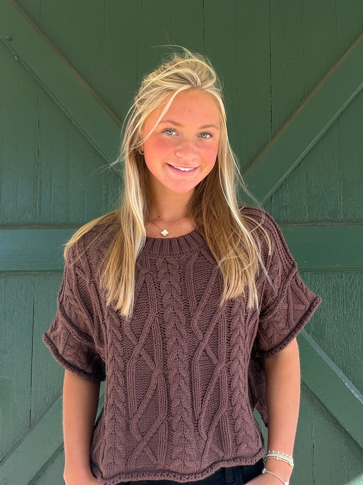 Dark brown cable knit short-sleeve sweater with crew neck and braided knit pattern
