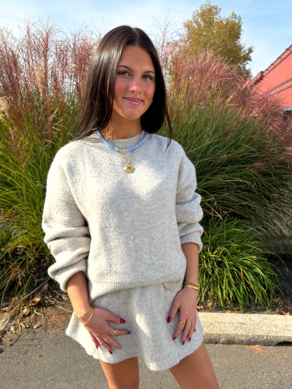 Oatmeal knit long-sleeve sweater paired with matching flared mini skirt, front view