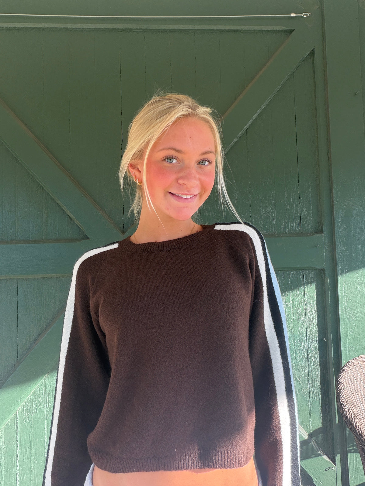 Dark brown knit sweater with contrast stripe trim and crew neckline