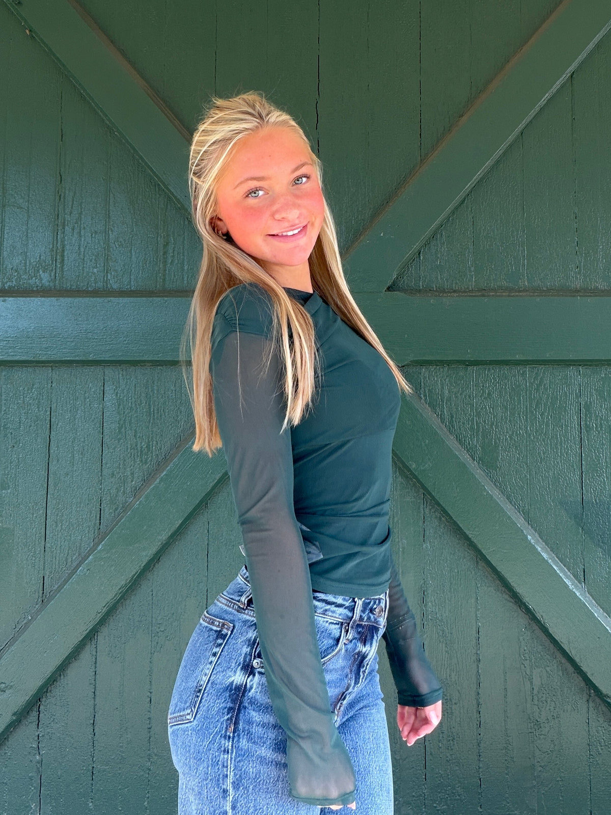 Hunter green mesh long-sleeve top, fitted crew neck, front side view