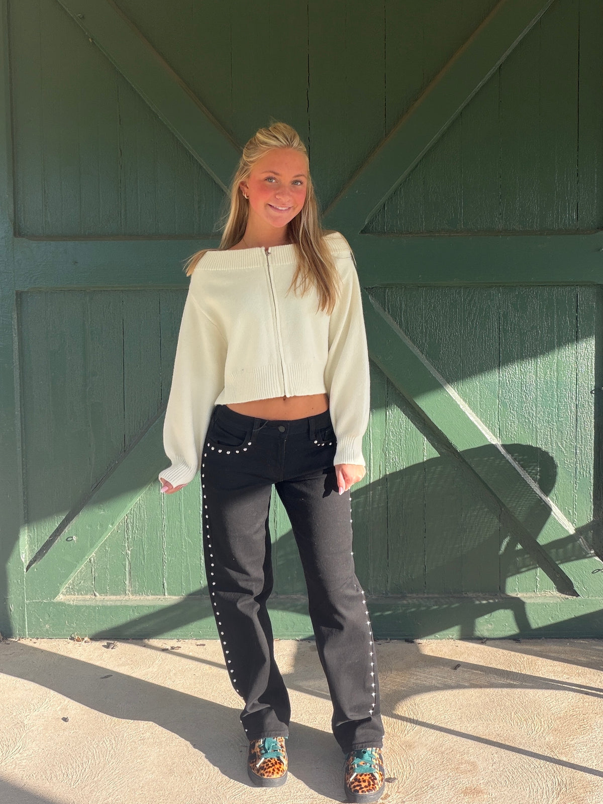 blond girl wearing cropped sweaters and studded side black jeans