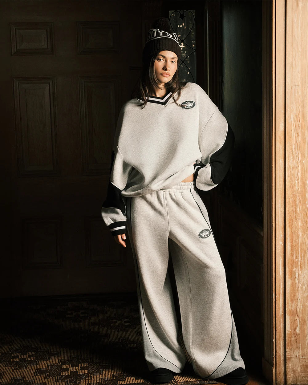 Grey V-neck sweatshirt with black-trim accents, paired with matching sweatpants