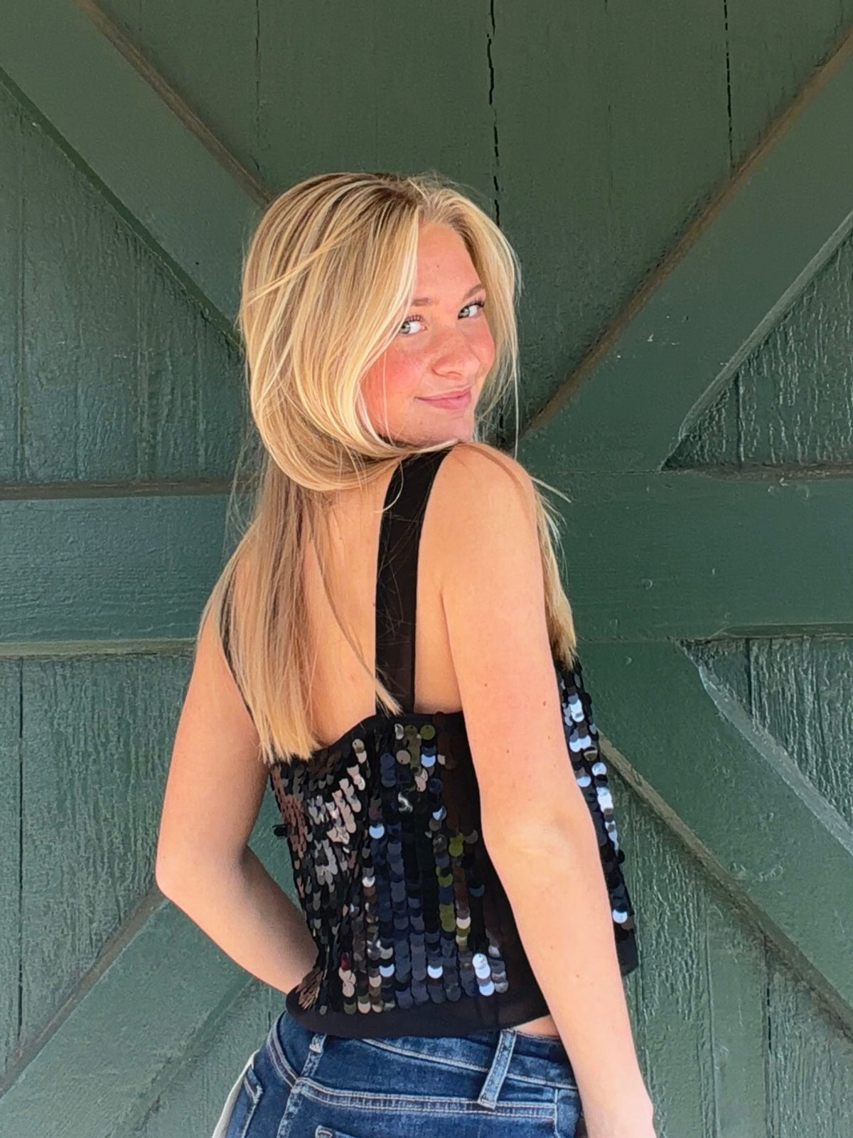 Lucy Paris Clara sequined top showing its back, wide straps, and sheer black hem