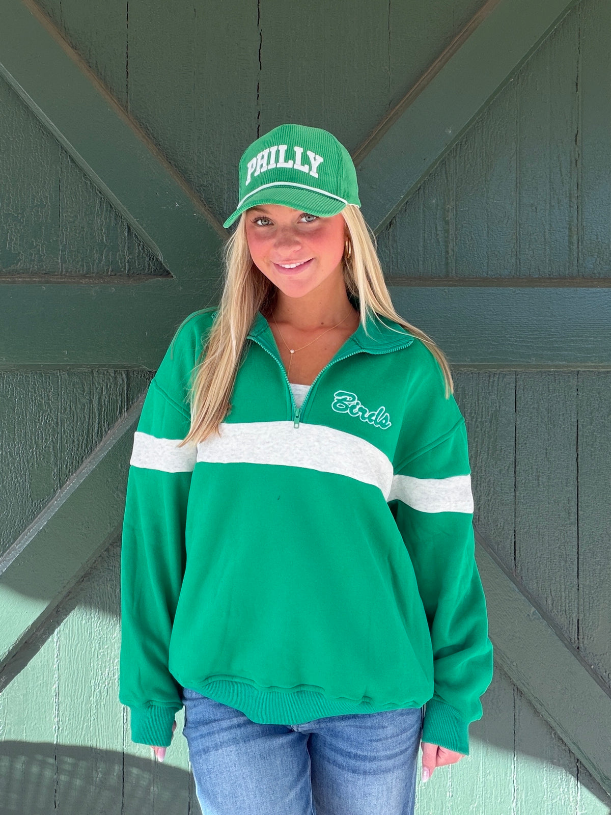 Green quarter-zip sweatshirt with white horizontal stripe and Eagles logo