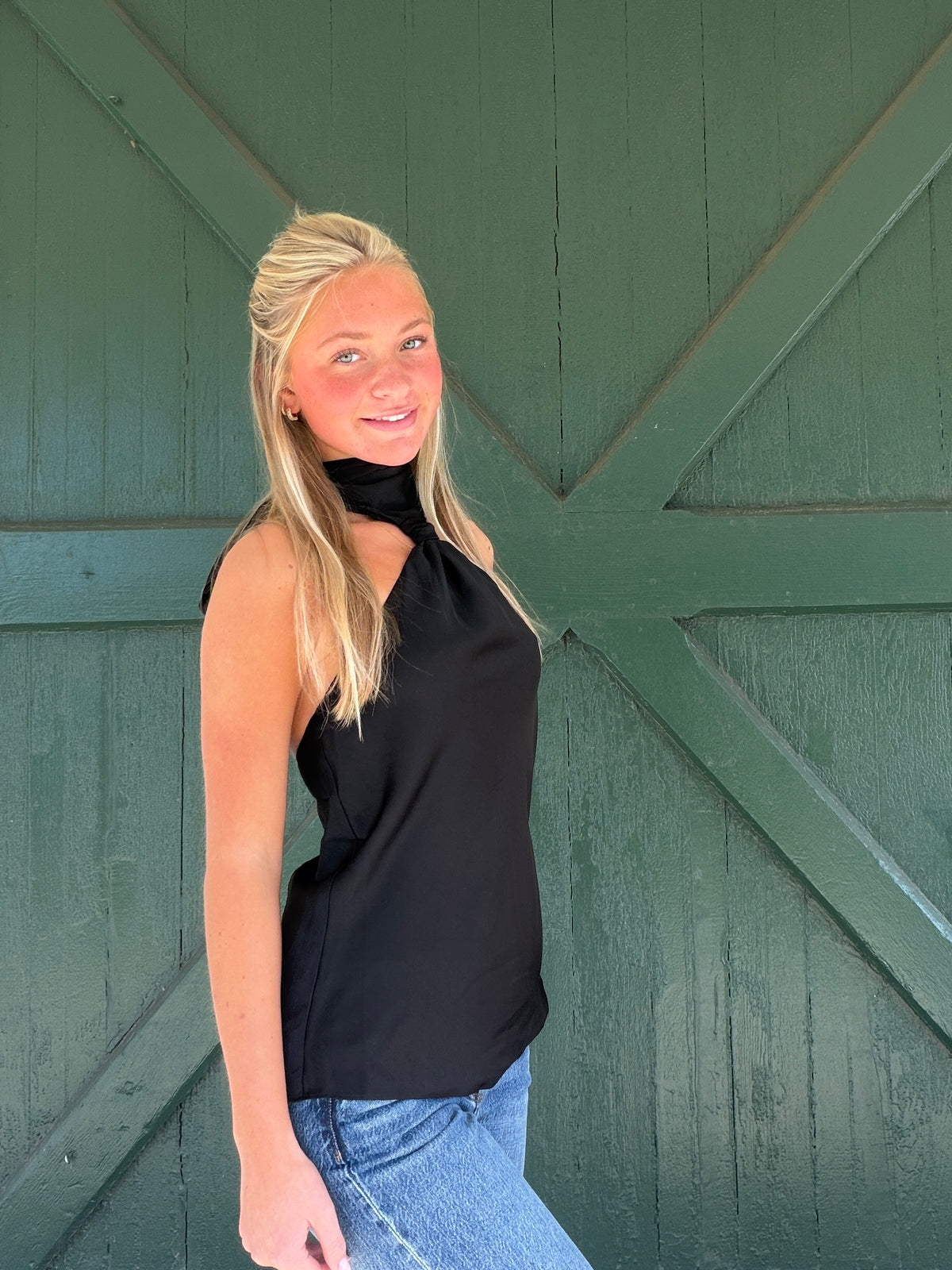 Black halter sleeveless top with high neck and fitted silhouette