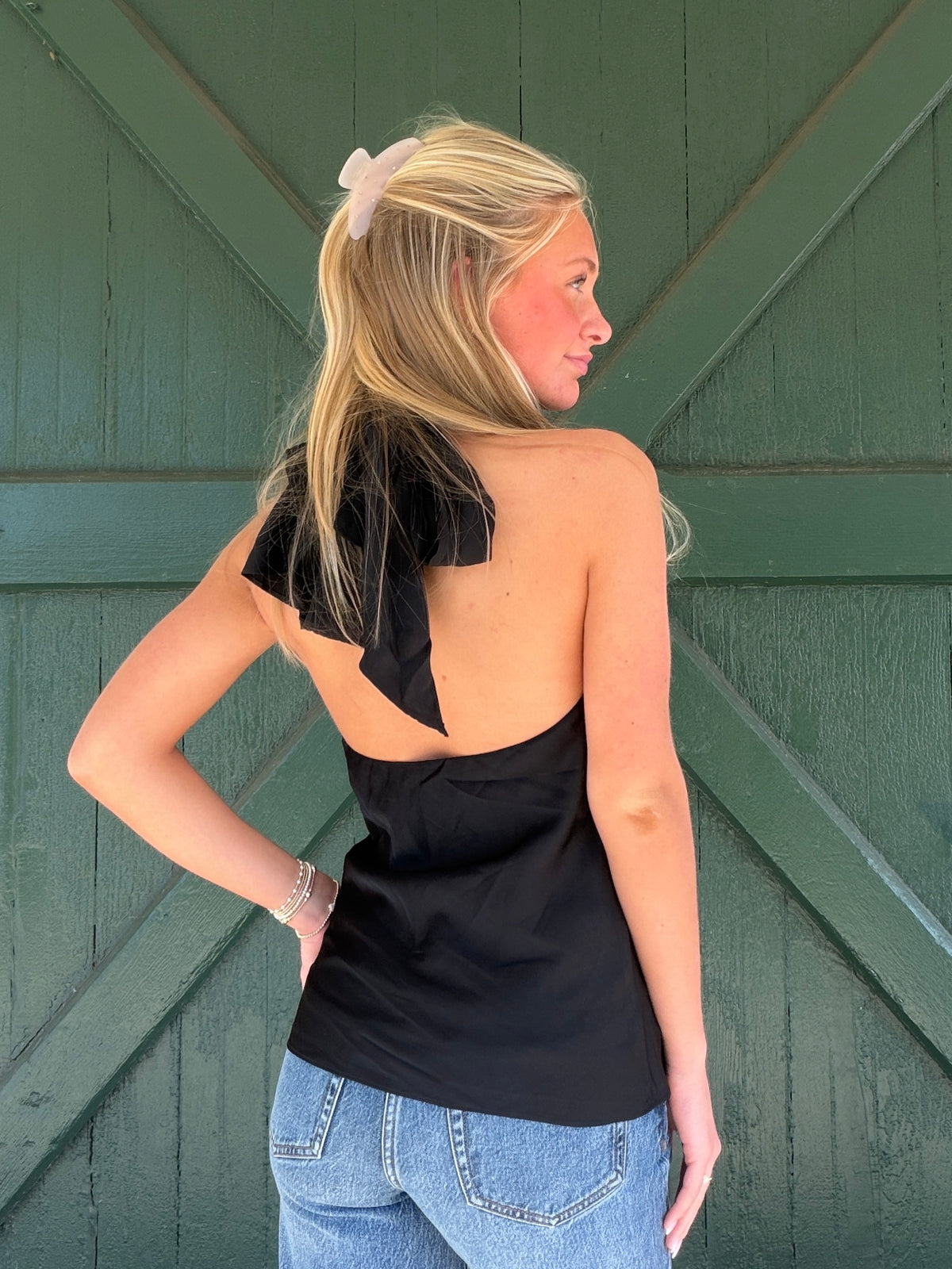 Black halter top with open back and draped bow detail