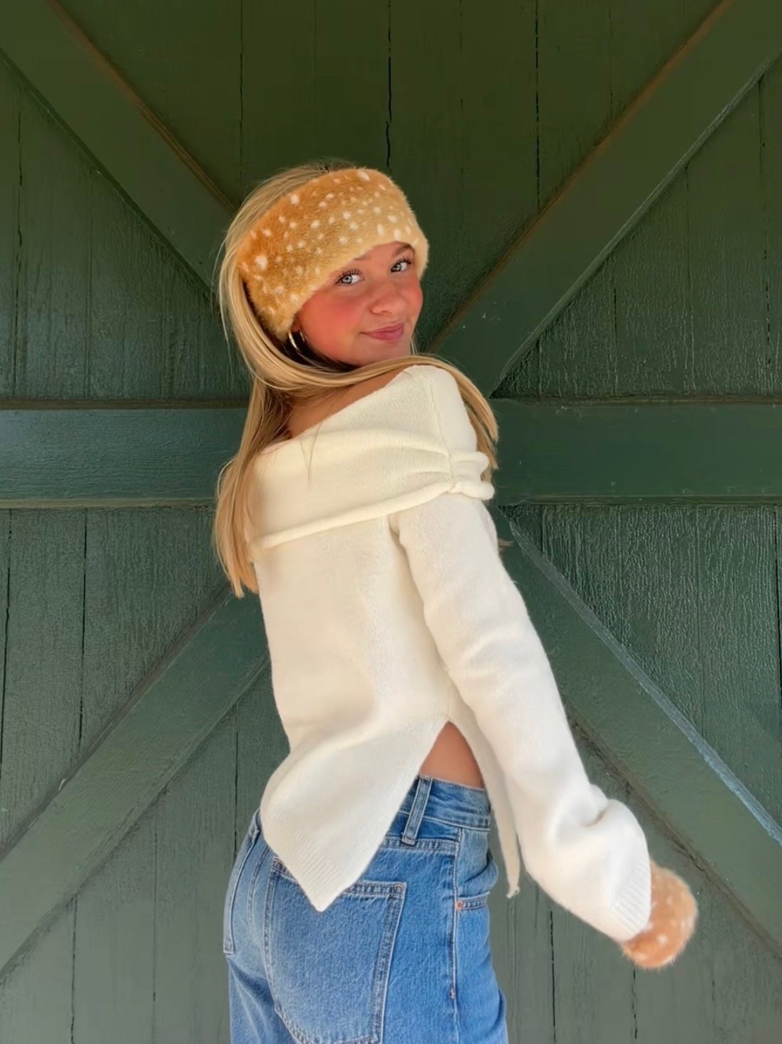 Back and side view of the ivory Audrey off-the-shoulder knit sweater, showing its side slit and ribbed hem.