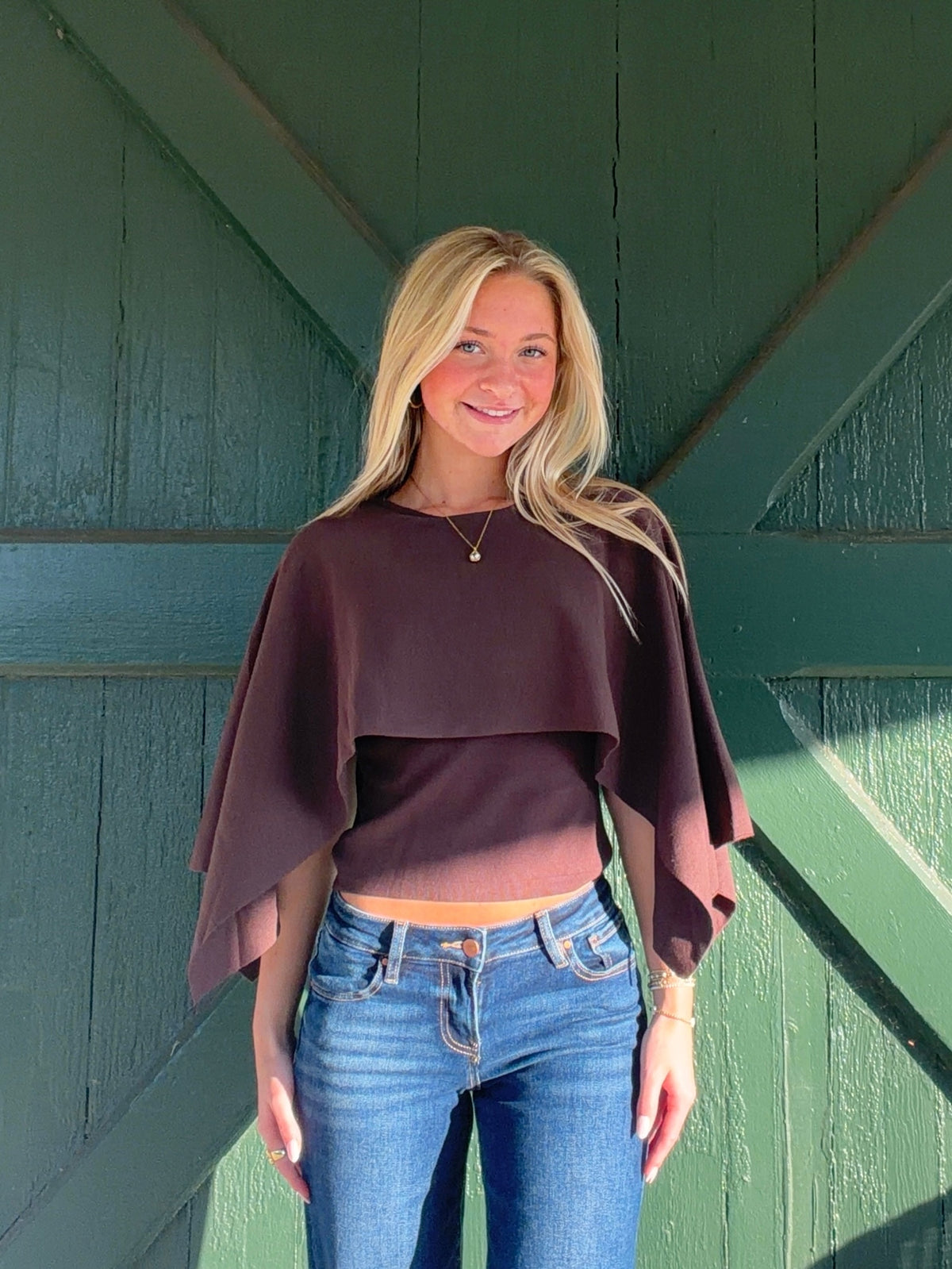 Brown cape sweater with a cropped body and draped, elbow-length sleeves, front view