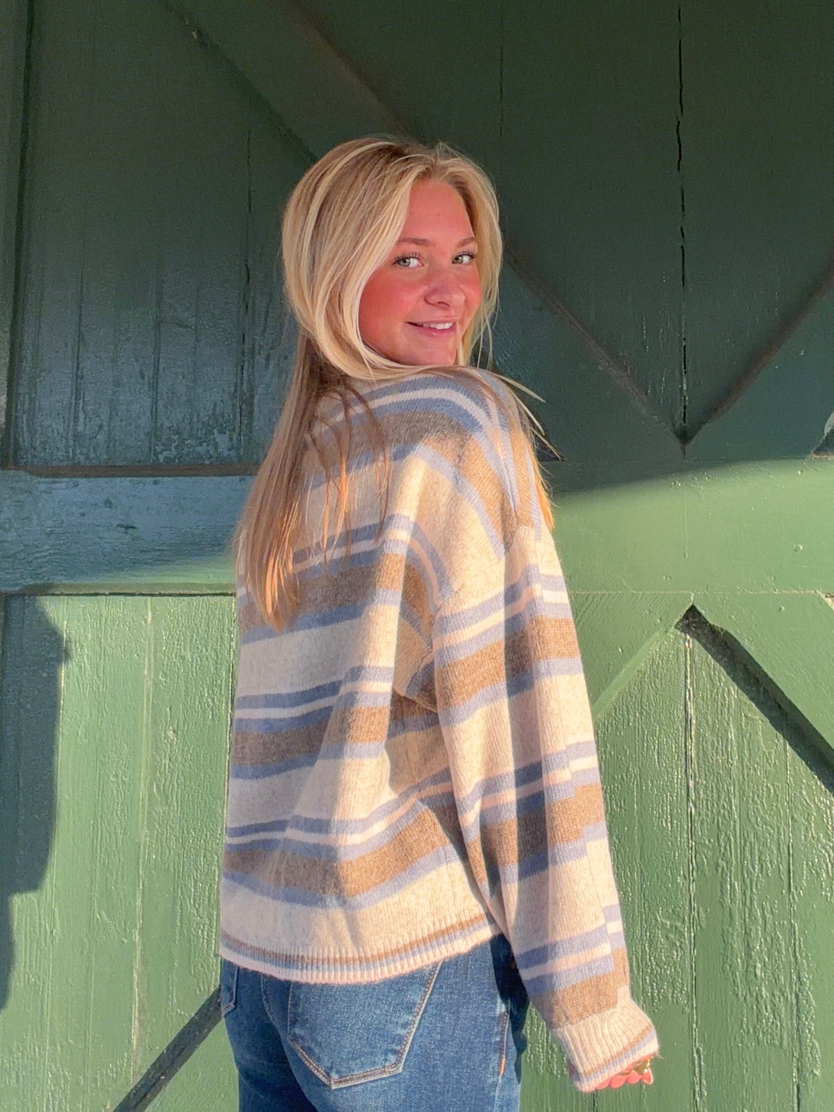 Striped cardigan shown from the side, with a relaxed fit and ribbed sleeve cuffs