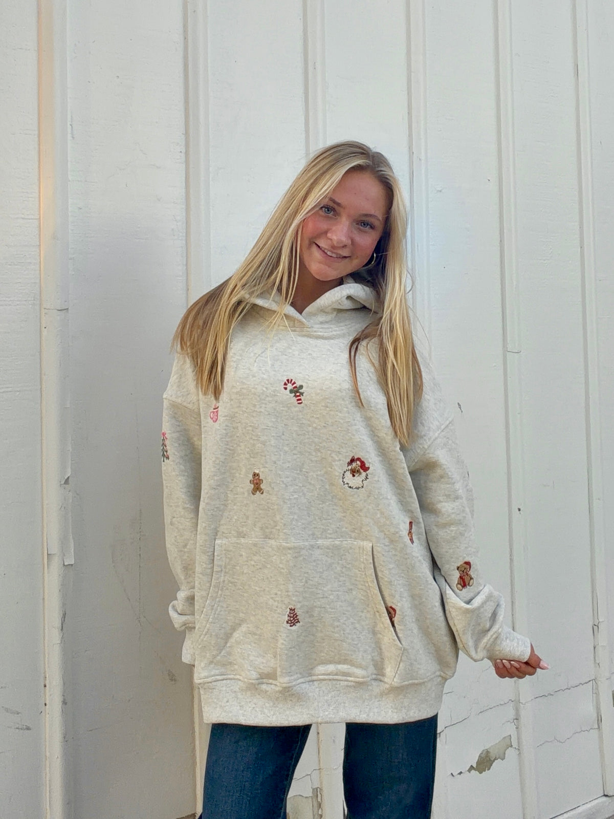 Oatmeal hoodie with scattered Christmas embroidery, drawstring hood, and front kangaroo pocket