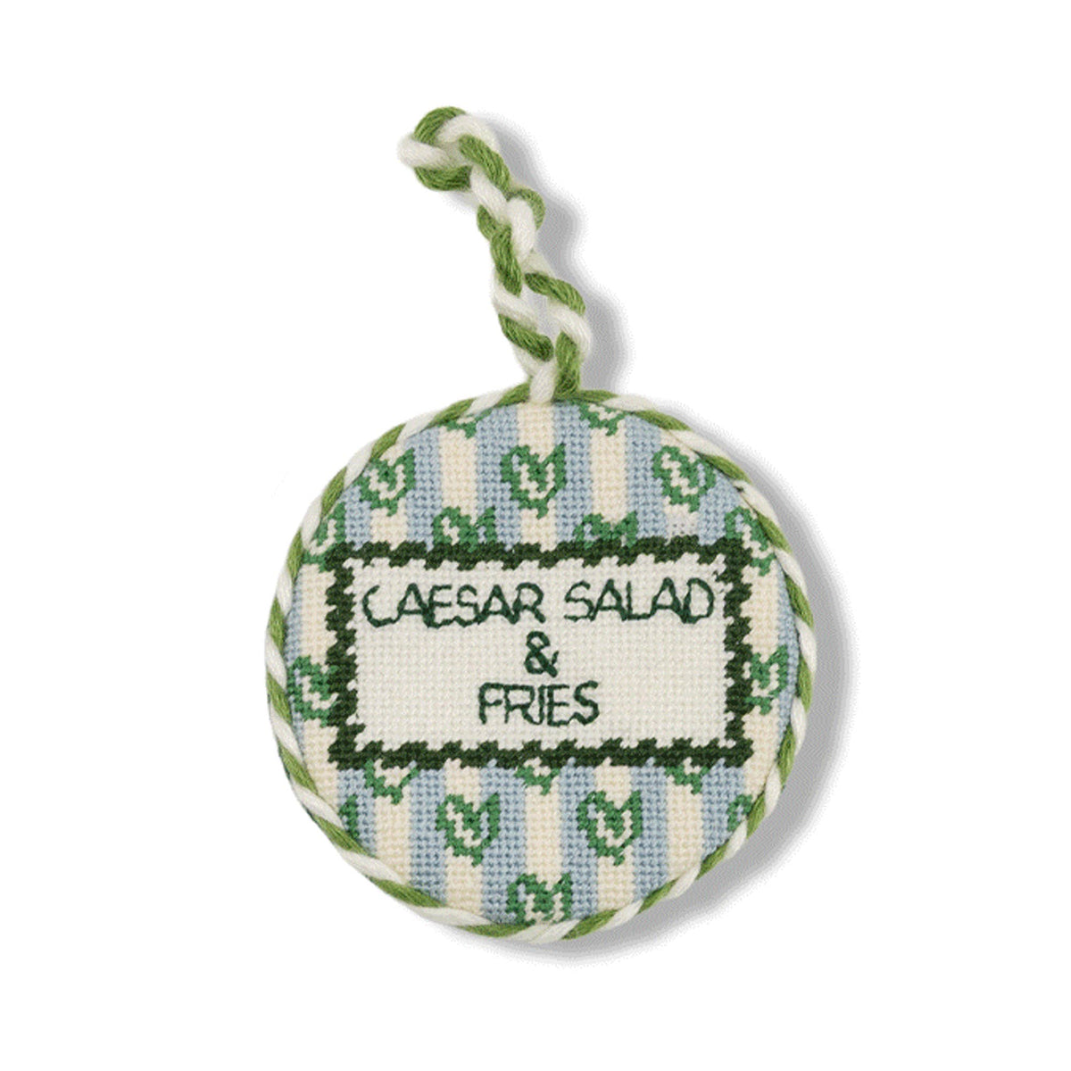 Round needlepoint ornament with green and blue border, text 'CAESAR SALAD & FRIES'